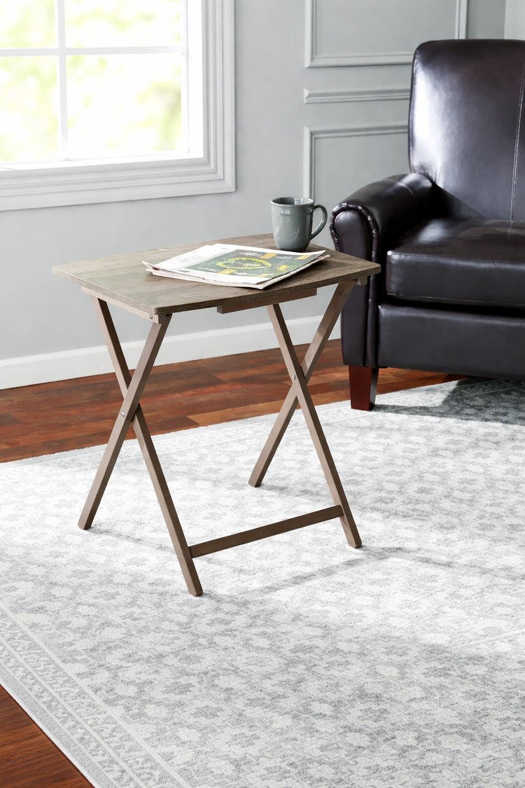Wooden side table with a magazine next to a leather chair in a living room.