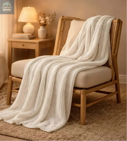 Cozy chair with a soft pearl blanket draped over it in a warm bedroom setting.